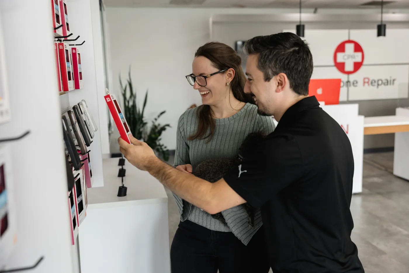 A customer and a store employee looking at phone cases together at the counter
